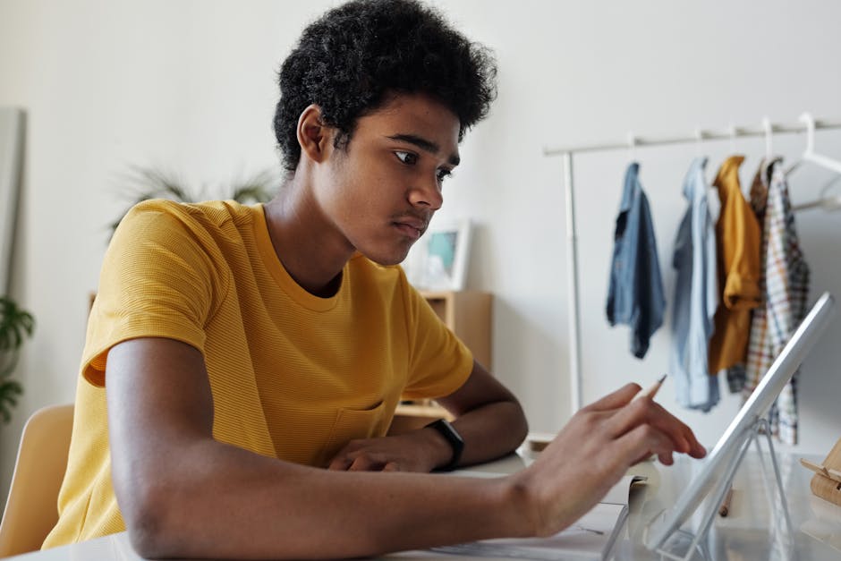 Teenage boy engaged in online learning using a tablet indoors