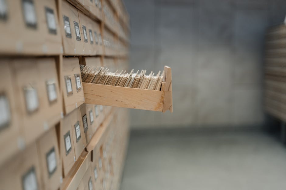 A vintage card catalog drawer in an archive library setting, highlighting organization and history